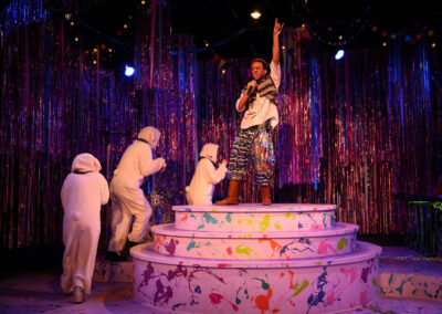 Aaron Bell on a platform and three cast members dressed as sheep